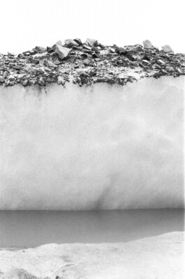 Suspended Landscape, 2019. Black-and-white analogue photograph showing a fragmented rocky ground seemingly suspended above a pale, almost empty spatial field.