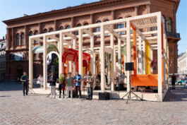 Creators of Dome Next Door at the opening of the urban art installation in Riga Old Town, Latvia, standing in front of the completed timber structure.