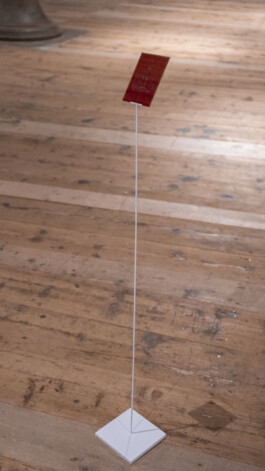 Detail of Unexposed, 2021, by Jurgis Gečys, showing one 4 × 5 inch photographic glass negative inscribed with an unrealised memory and mounted on a slender metal stand.