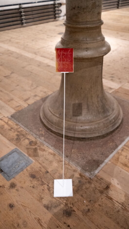Detail of Unexposed, 2021, by Jurgis Gečys, showing a 4 × 5 inch photographic glass negative inscribed with an unrealised memory and mounted on a slender metal stand.